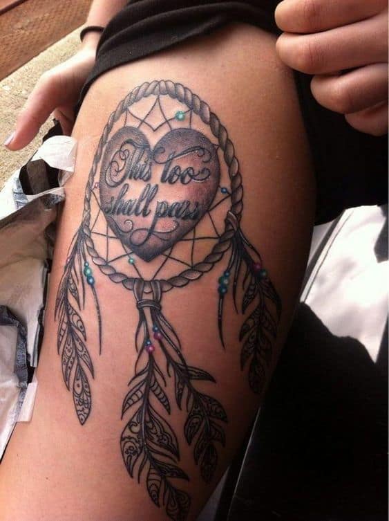 A stunning "This too shall pass" tattoo designed within a dreamcatcher, symbolizing protection, resilience, and the transient nature of life's struggles.