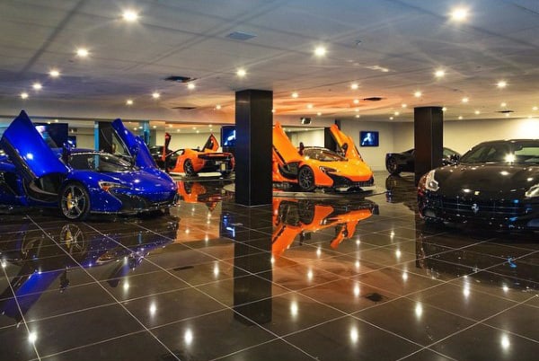 Luxury basement garage featuring modern design, glossy black tiles, and supercars.