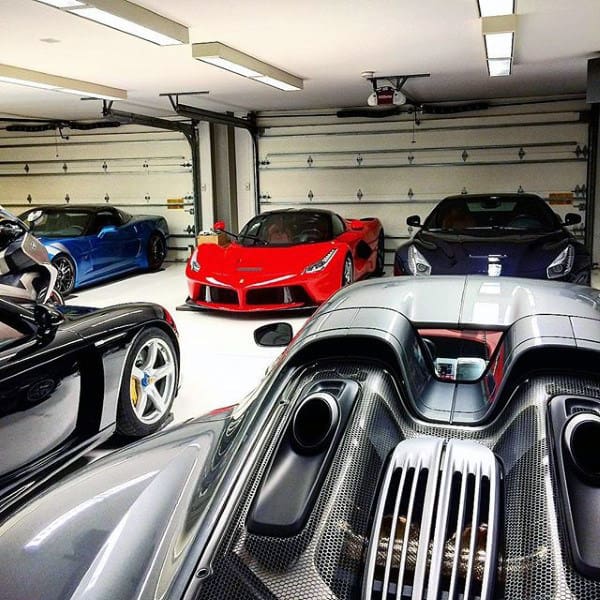 A luxury garage showcasing stunning Ferrari and Porsche supercars in pristine condition.