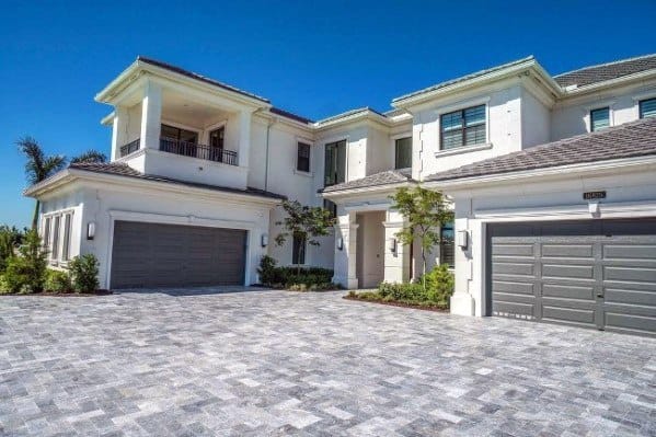 Expansive driveway with light gray interlocking stone pavers in a clean and polished finish.