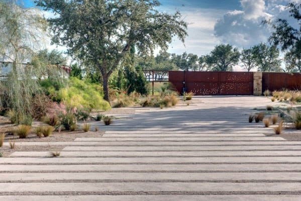 Concrete driveway with parallel slabs separated by gravel inlays.