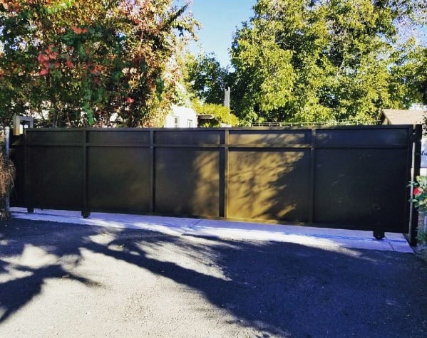 A sleek black modern driveway gate with a minimalist, solid panel design.