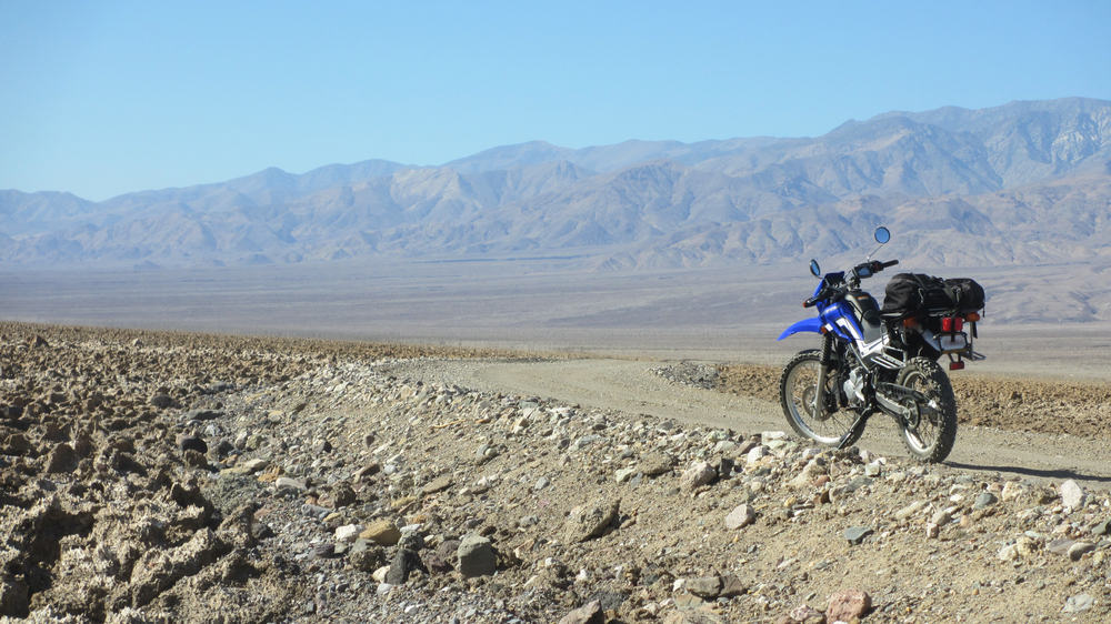 lonely dual sport bike on a dirt road in death valley