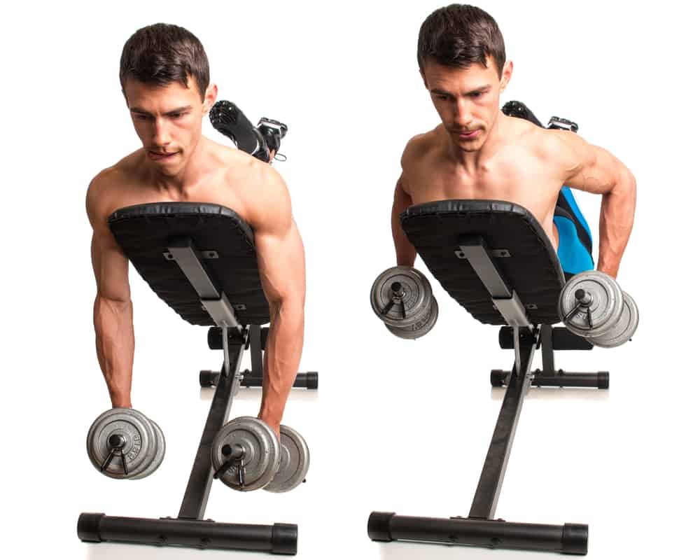 young man doing dumbbell incline row exercise, studio shot