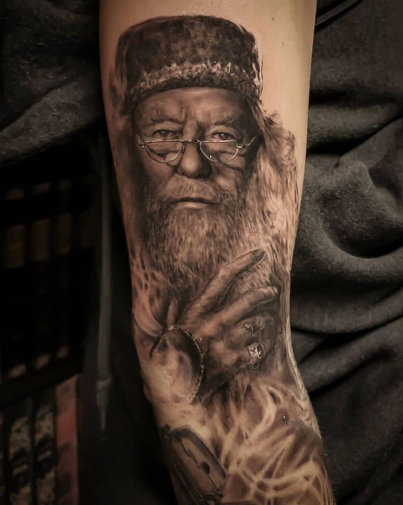Realistic black and grey tattoo of Albus Dumbledore, featuring his wise gaze, iconic glasses
