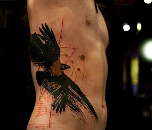 Tattoo of a crow on a person's torso side, with geometric and abstract elements