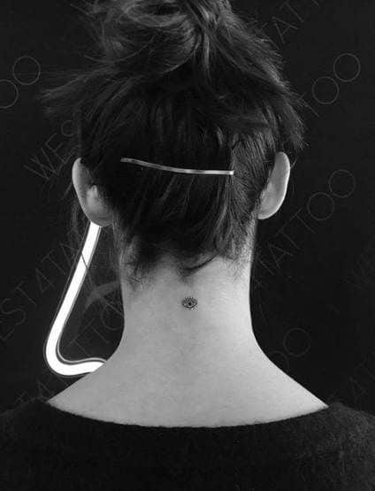 Small minimalist tattoo of an all-seeing eye with radiating lines, inked in black at the nape of the neck.