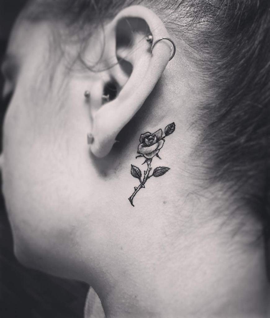 Black and white tattoo of a rose on the neck