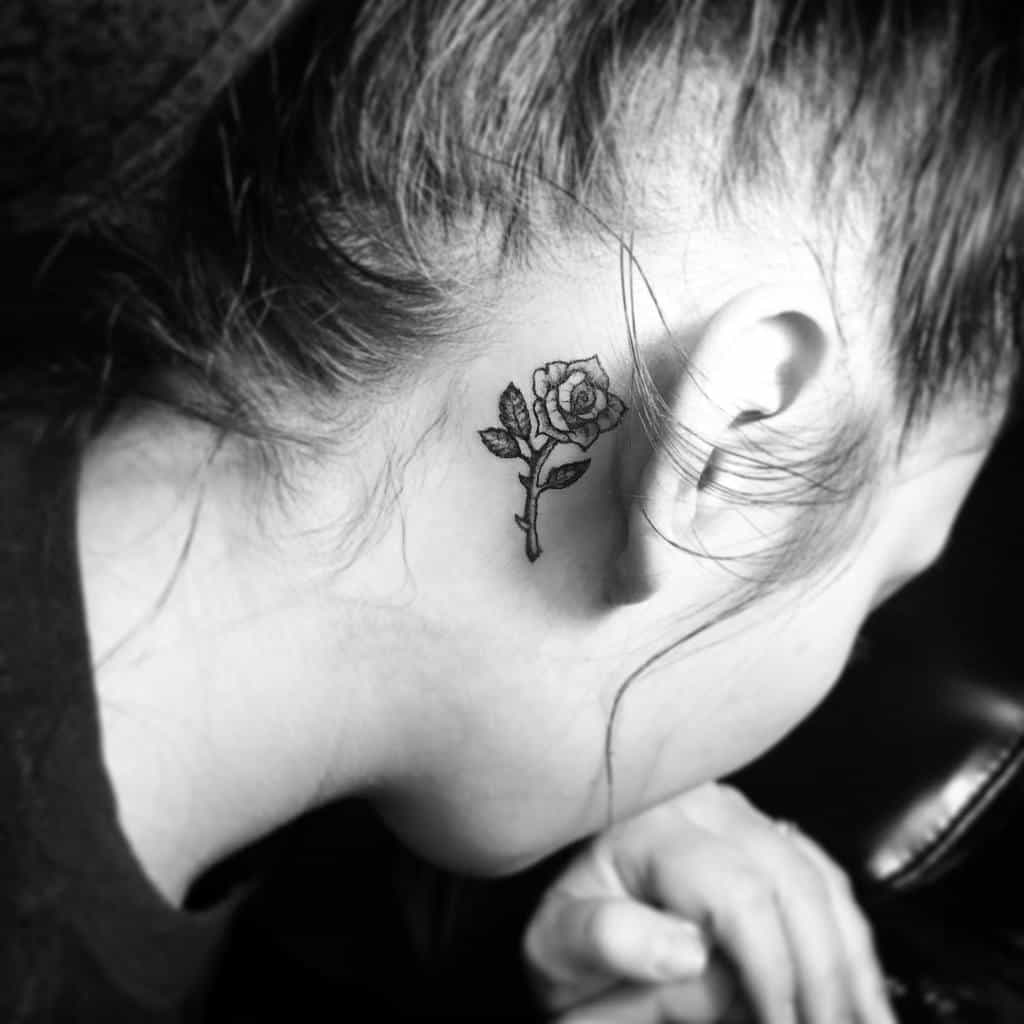 A person with a small rose tattoo behind their ear