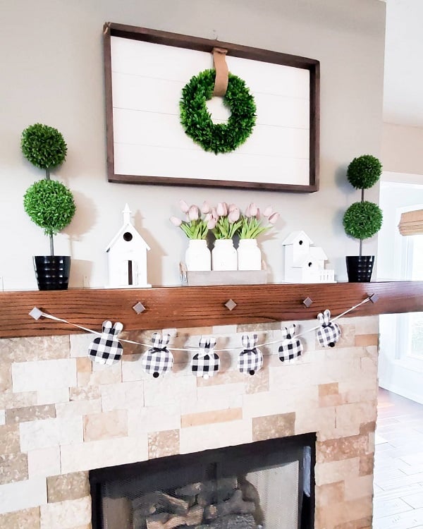 stone fireplace with wood beam mantel and wall mirror