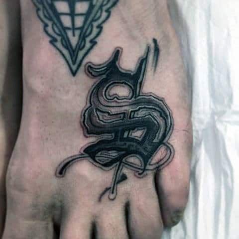 Foot tattoo featuring intertwined letters in black ink and a larger geometric tattoo near the ankle