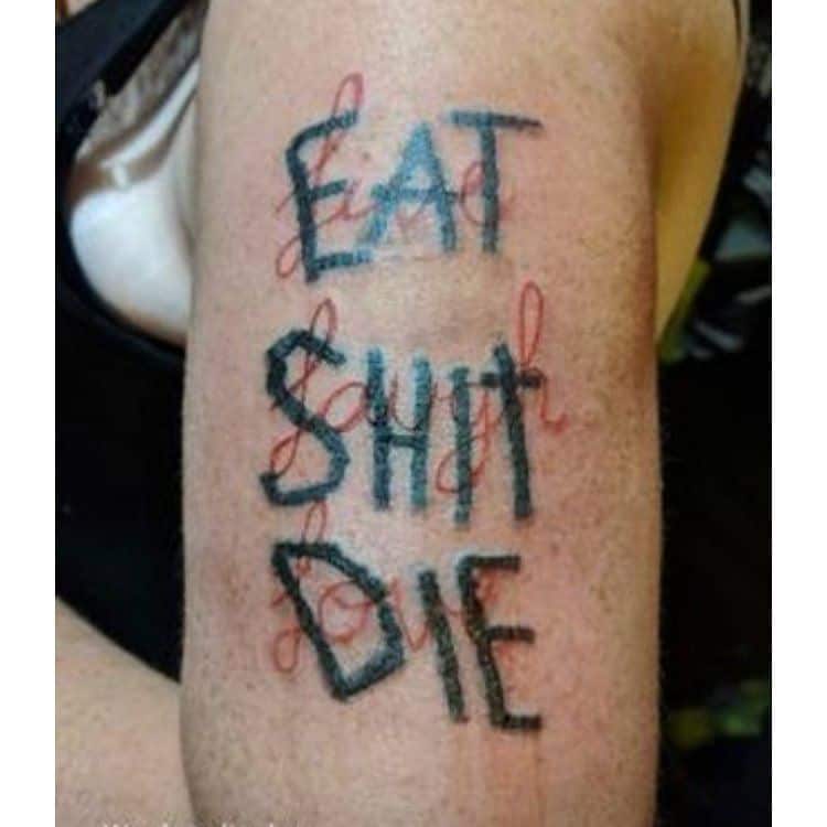 Funny tattoo with bold black text saying 'EAT SH*T DIE,' cleverly layered over elegant cursive words for contrast and irony.