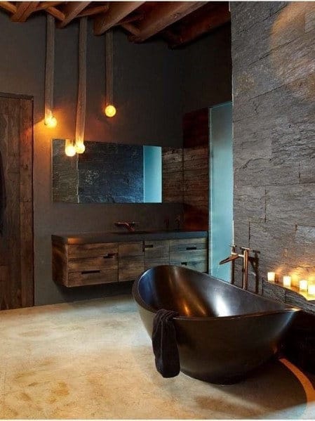 Luxury bathroom with black freestanding tub, dark wood vanity, and hanging pendant lights.