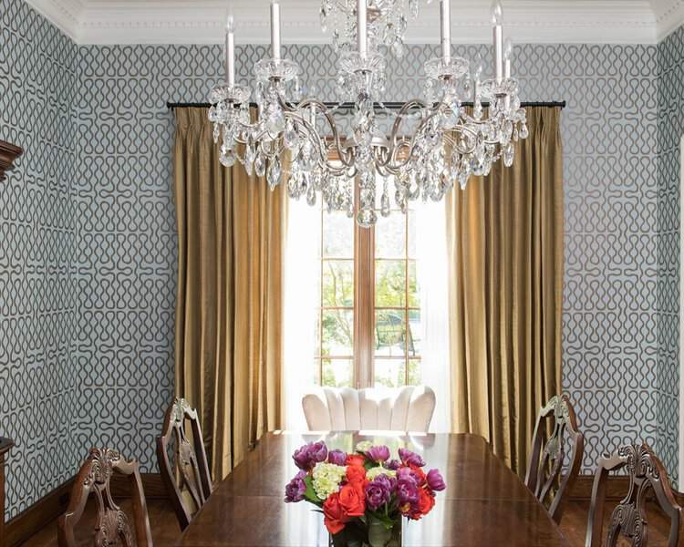 Elegant dining room with gold curtains, a crystal chandelier, and a classic wooden dining set.