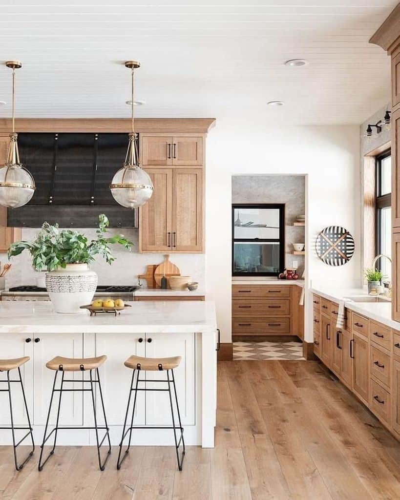 elegant kitchen brown wood cabinets with black accents white island three stools