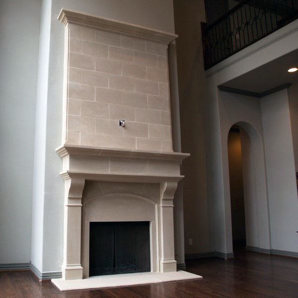 Elegant stone fireplace with tall mantle and classic architectural details in a modern room.
