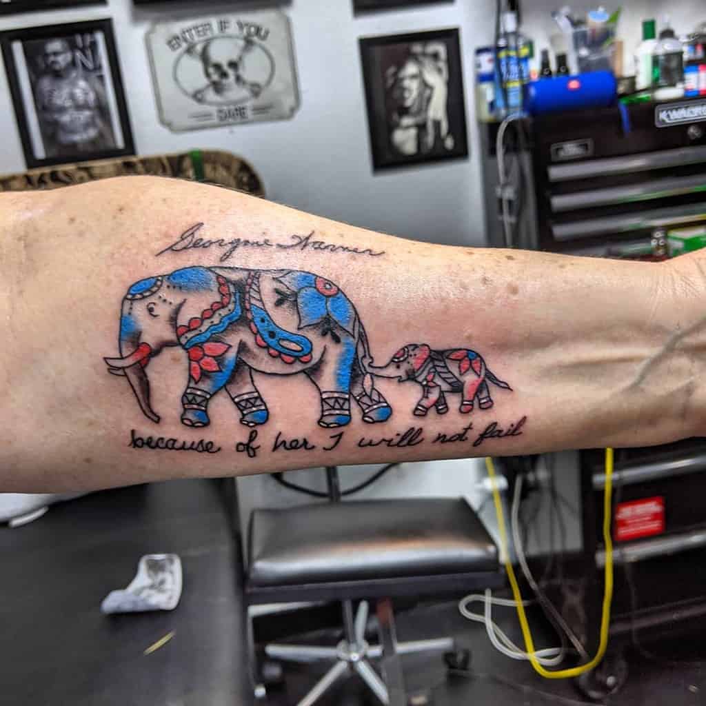 Mother-daughter tattoo featuring an elephant and calf with vibrant blue and red designs, accompanied by the words 'because of her I will not fail.' and 'Georgone Aarmer'