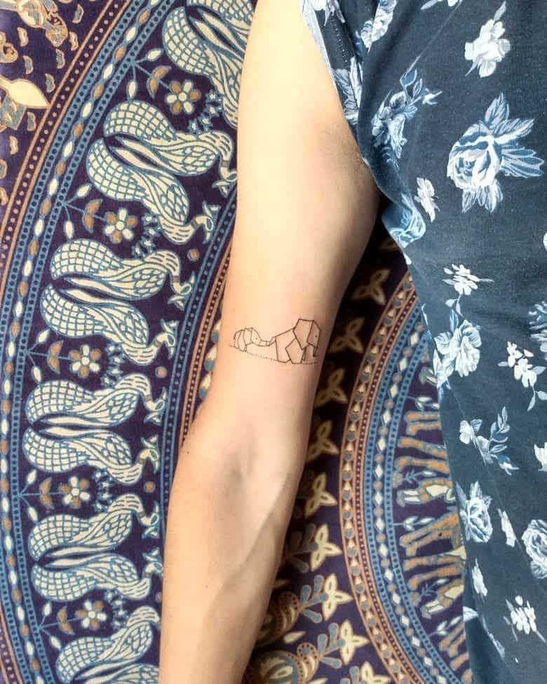 Minimalist line tattoo of two elephants forming a heart shape with their trunks, symbolizing family, love, and connection.