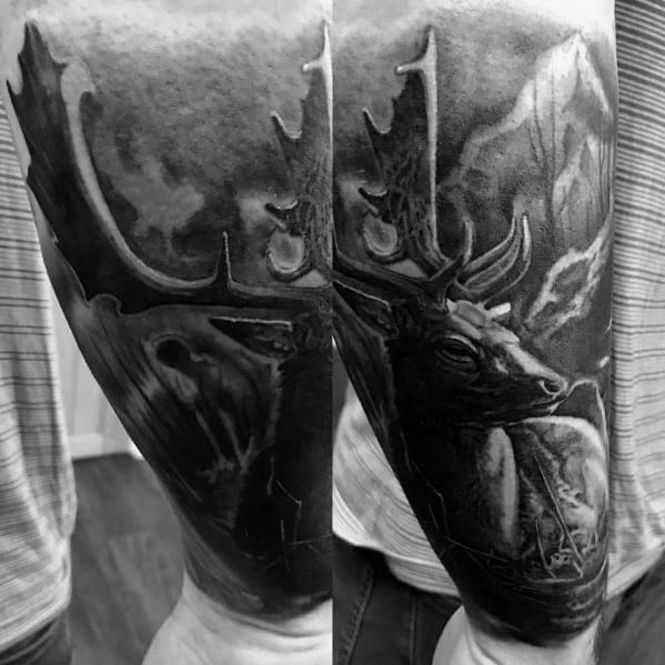 Realistic black and grey elk tattoo sleeve with detailed shading, a mountain background, and intricate antler work for a bold, nature-inspired look.