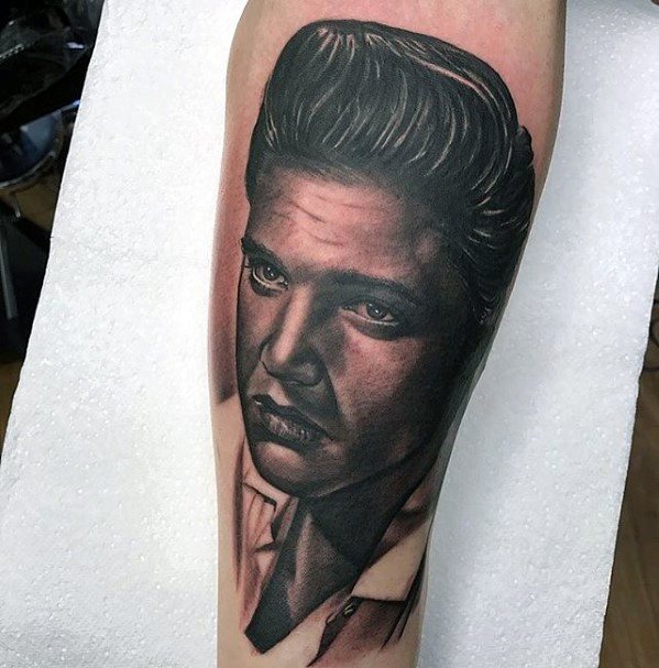 Realistic Elvis Presley tattoo on the calf, with lifelike shading and a serious expression that captures his signature style.