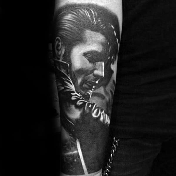 Black and grey Elvis Presley tattoo on forearm, capturing him in a dynamic pose with slicked-back hair and leather jacket.