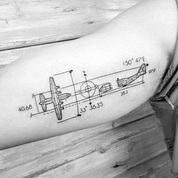 Tattoo of an airplane blueprint with precise measurements, coordinates, and compass markings, resembling an aviation engineering diagram on the bicep.