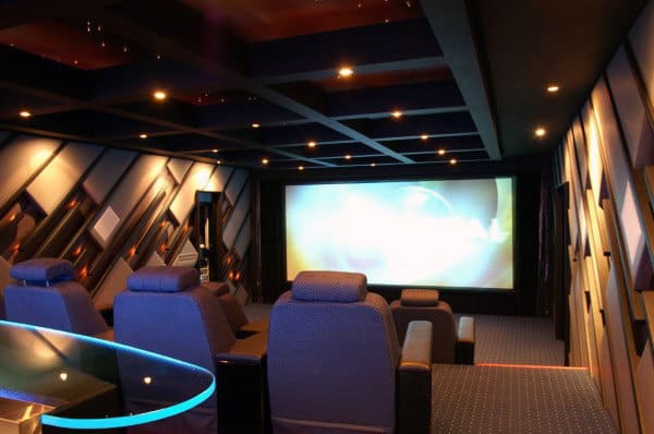 A luxurious home theater with plush seating and a large screen