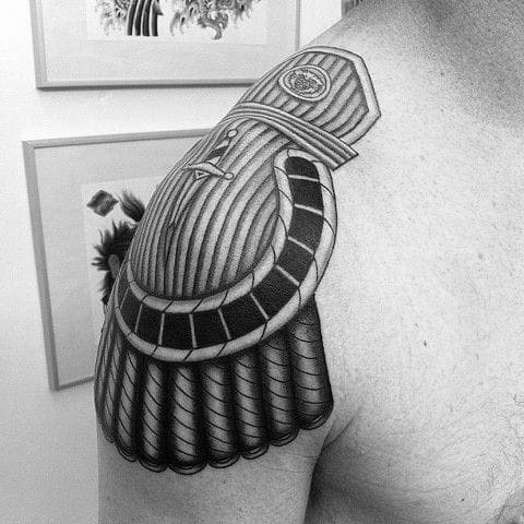 Bold epaulette tattoo with clean-lined patterns, layered shoulder plating, and high-contrast shading for a structured look.