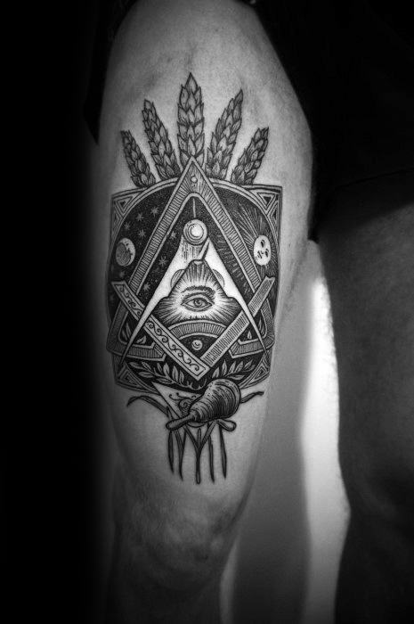 Tattoo featuring an all-seeing eye within a Masonic symbol, with wheat stalks, celestial elements, and an anatomical heart below.