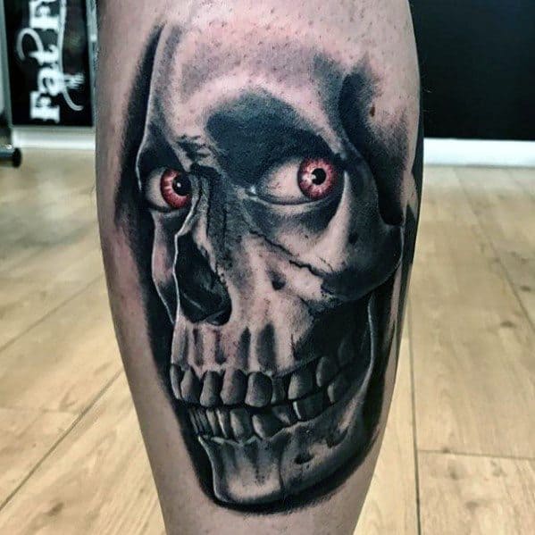 Evil Dead tattoo of a grinning skull with eerie red eyes and deep shadows, capturing a haunting and intense horror vibe.
