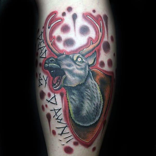 Evil Dead tattoo of the mounted deer head with crazed eyes, blood splatter, and the phrase "Dead by Dawn!!" in horror-style text.