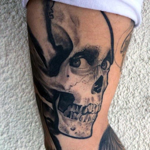 Black and grey Evil Dead tattoo of a skull with a human eye in the socket, giving a haunting stare and eerie undead expression.