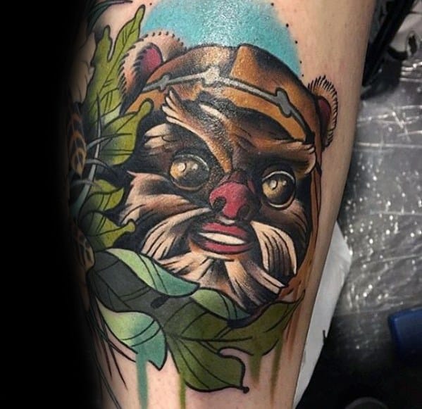 Bold Ewok tattoo with bright eyes, leafy background, and blue sky detail, showcasing a playful and colorful design style.