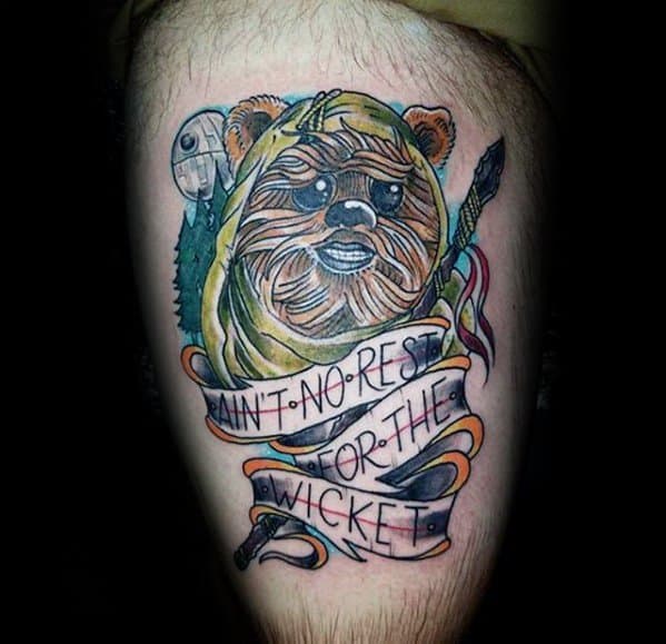 Ewok tattoo wrapped in a ribbon that reads "Ain’t No Rest for the Wicket," with colorful accents and a forest-themed background.