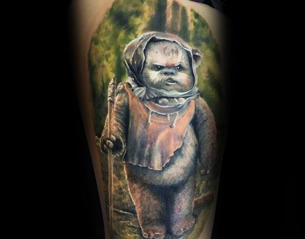 Realistic Ewok tattoo standing in a forest, holding a spear with a determined expression and soft, detailed shading.