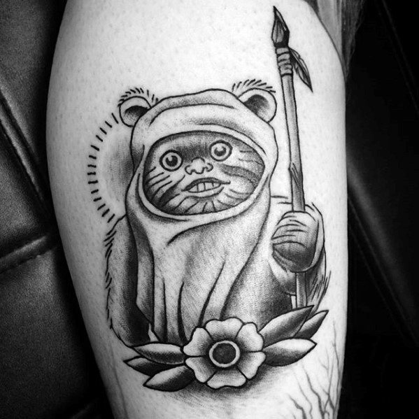 Black and grey Ewok tattoo with a flower at the bottom, holding a spear and surrounded by dotted halo-style lines.