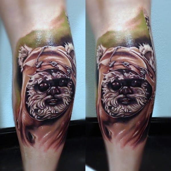 Hyper-realistic Ewok tattoo with detailed fur texture and soft shading, featuring a focused expression and a nature-inspired background.