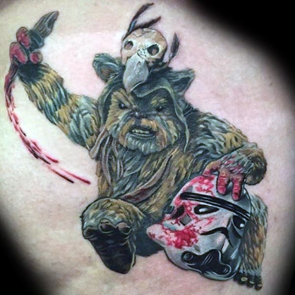 Fierce Ewok tattoo wielding a bloody blade, wearing a skull headdress, and gripping a bloodied Stormtrooper helmet.