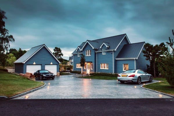 Beautifully lit driveway with subtle ground lighting, illuminating the paved path and enhancing the modern home exterior at dusk