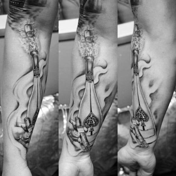 Forearm tattoo of a champagne bottle and cigar, emitting smoke, in grayscale.