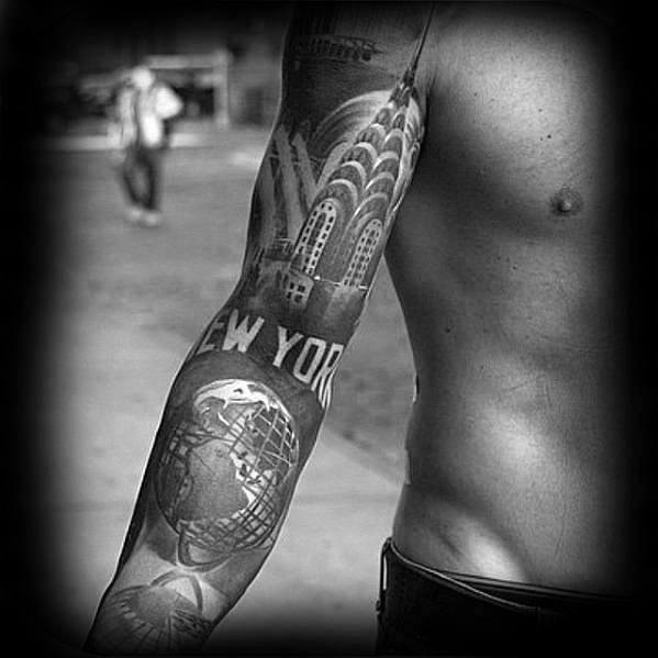 Black-and-grey Chrysler Building sleeve tattoo featuring the NYC skyline, globe sculpture, and bold "New York" text for a striking urban tribute.