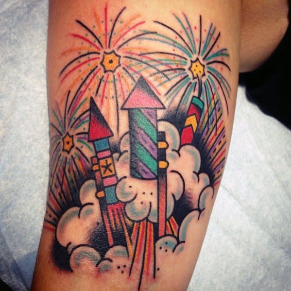 Tattoo of colorful fireworks launching from clouds, featuring vibrant rocket designs and bright bursts in a bold traditional style.