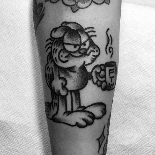 Black and gray Garfield tattoo with a grumpy look, holding a coffee mug labeled 'FTW'—a bold and edgy take on the classic character.