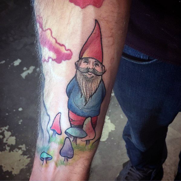 Colorful gnome tattoo with a red hat, blue shirt, and red pants, standing on mushrooms with a whimsical background of clouds and pastel fungi.