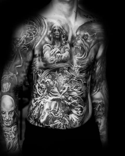 Black and grey full chest and torso tattoo featuring demons, eerie faces, and a dramatic battle scene for a dark and gothic aesthetic.