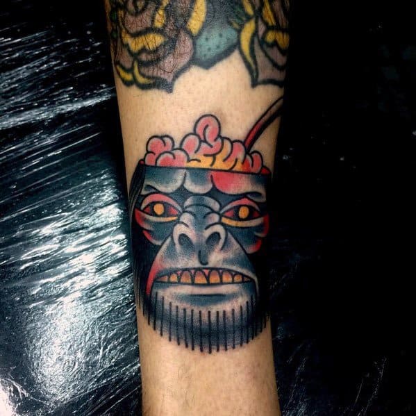 Bold Indiana Jones tattoo featuring a monkey head with an open skull, a spoon inside, inspired by the Temple of Doom feast scene.