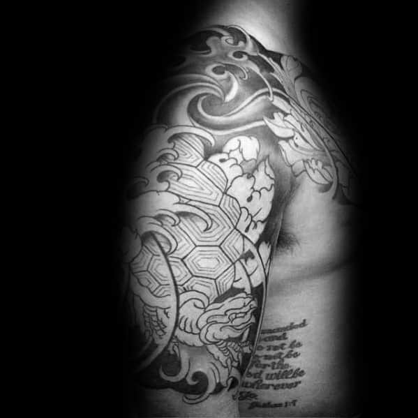 Black and grey Japanese turtle tattoo on the shoulder and chest with intricate waves, floral elements, and geometric shell patterns.