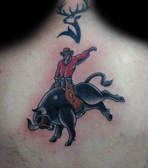 Bold and colorful tattoo of a cowboy riding a bucking bull, featuring strong outlines, vibrant red and black shading, and dynamic motion.
