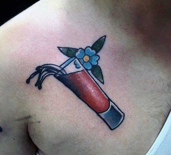 Minimalist shot glass tattoo with red liquid splashing out, accented by a small blue flower and leaves, placed on the upper chest.