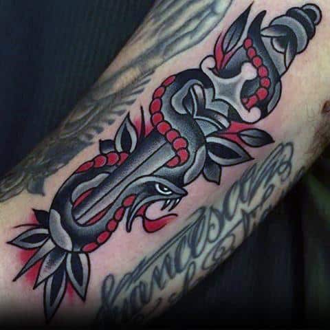 Bold traditional snake and dagger tattoo on forearm, featuring black and red ink with sharp details and a classic old-school design.